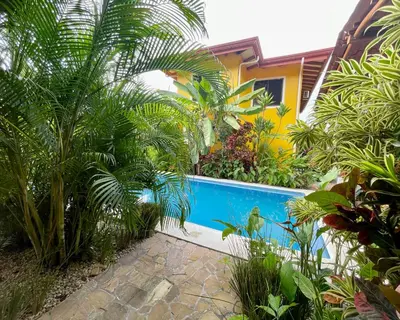 a swimming pool in front of a house with plants at The Inner Light Yoga Lodge in Sámara