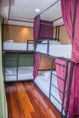 two bunk beds in a room with a wooden floor at Gardens House, Airport Juan Santamaría, Alajuela, San José in Alajuela City