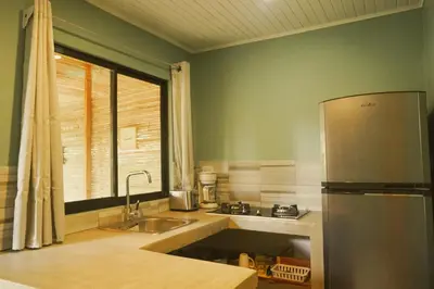 a kitchen with a stainless steel refrigerator and a window at GALA Santa Teresa Apartments 80m from the Beach in Santa Teresa Beach