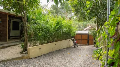 a garden with a motorcycle parked next to a house at GALA Santa Teresa Apartments 80m from the Beach in Santa Teresa Beach