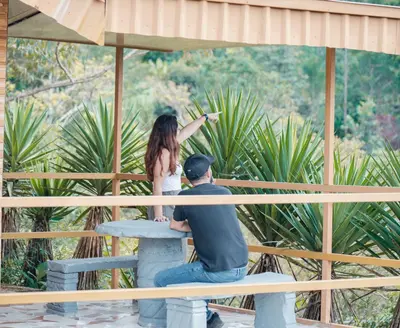 a man and a woman sitting on a bench at Cabañas La Hacienda in San Pablo