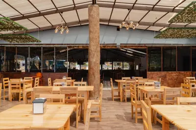 an empty restaurant with wooden tables and chairs at Cabañas La Hacienda in San Pablo