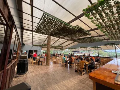 a group of people sitting at tables in a restaurant at Cabañas La Hacienda in San Pablo
