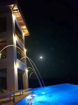 a building with a swimming pool at night at Casa Amarillo Jaco Beach Costa Rica in Jacó