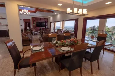 a dining room and living room with a table and chairs at Casa Amarillo Jaco Beach Costa Rica in Jacó