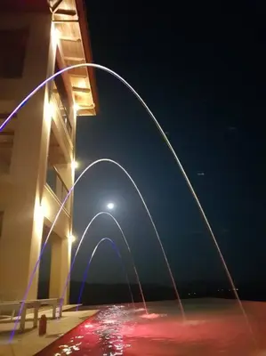 a building with a fountain in front of it at night at Casa Amarillo Jaco Beach Costa Rica in Jacó