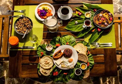 a wooden table topped with plates of food on it at Macaw Lodge in Carara