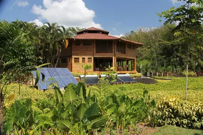 a house with solar panels in front of it at Macaw Lodge in Carara