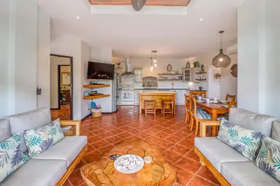 a living room with a couch and a table at Casa Mimosa Poolside in Playa Flamingo