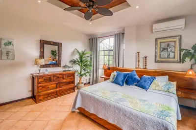 a bedroom with a bed and a ceiling fan at Casa Mimosa Poolside in Playa Flamingo