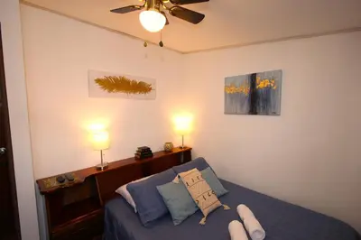 a bedroom with a bed with a pair of feet on it at F&M Guesthouse in San José