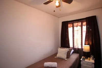 a bedroom with a bed with a ceiling fan and a window at F&M Guesthouse in San José