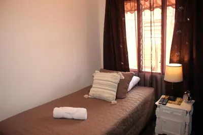 a bedroom with a bed with a pillow and a window at F&M Guesthouse in San José