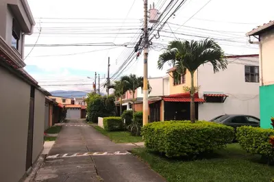 an empty alley with palm trees and buildings at F&M Guesthouse in San José