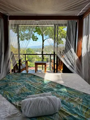 a bed in a room with a view at Villas In Sueño in Manuel Antonio