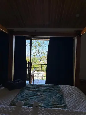 a bedroom with a bed with a view of a window at Villas In Sueño in Manuel Antonio
