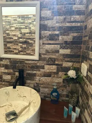 a bathroom with a brick wall with a sink at Villas In Sueño in Manuel Antonio