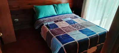 a bed with a quilt on it in a room at Whale Melody Marabi in Uvita