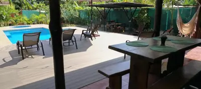 a patio with a table and chairs and a pool at Whale Melody Marabi in Uvita