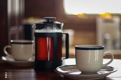 two coffee cups on a table with a coffee pot at Whale Melody Marabi in Uvita
