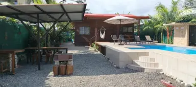 a house with a swimming pool and an umbrella at Whale Melody Marabi in Uvita