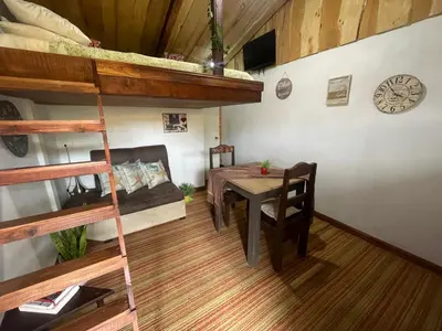 a room with a table and a dining room with bunk beds at Poas Volcano Rooms in Fraijanes
