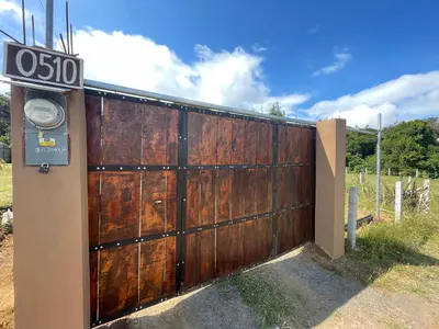 a wooden gate with a sign on it at Poas Volcano Rooms in Fraijanes