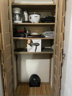 a book shelf with a hair dryer in a room at Poas Volcano Rooms in Fraijanes