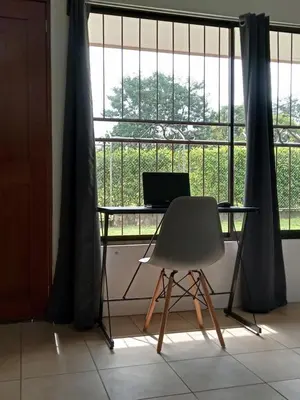 a desk and a chair in front of a window at KAPALIZ in Tigre