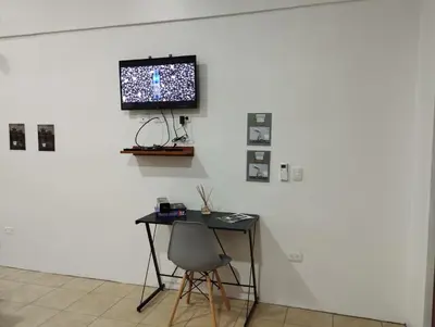 a room with a desk and a television on a wall at KAPALIZ in Tigre