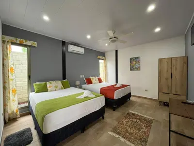 a bedroom with two beds and a ceiling fan at Brisas del Volcán BnB in Fortuna