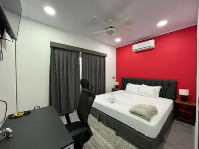 a bedroom with a bed and a red wall at Brisas del Volcán BnB in Fortuna
