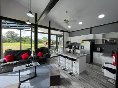 a living room with a couch and a kitchen at Brisas del Volcán BnB in Fortuna