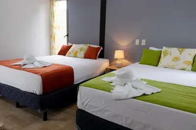 two beds with towels on them in a room at Brisas del Volcán BnB in Fortuna