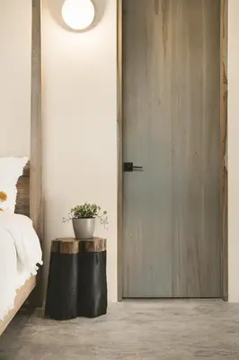 a bedroom with a wooden door and a potted plant at Casa Arcilla NEW LISTING in Nosara