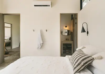 a white bedroom with a bed and a mirror at Casa Arcilla NEW LISTING in Nosara