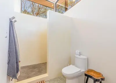 a bathroom with a toilet and a window at Casa Arcilla NEW LISTING in Nosara