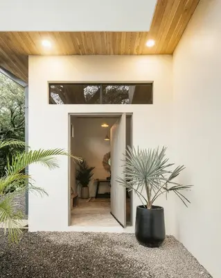 a pivot door to a house with a potted plant at Casa Arcilla NEW LISTING in Nosara