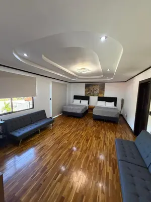 a living room with two beds and a couch at Zeus Guest house & Car Rental Free SJO Airport Shuttle-NATIONWIDE PRÍVATE SHUTTLE SERVICE in La Garita