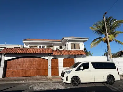 a white van parked in front of a house at Zeus Guest house & Car Rental Free SJO Airport Shuttle-NATIONWIDE PRÍVATE SHUTTLE SERVICE in La Garita