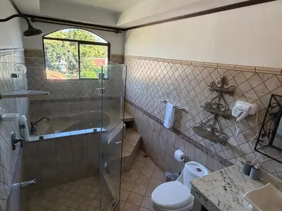 a bathroom with a shower and a toilet and a sink at Zeus Guest house & Car Rental Free SJO Airport Shuttle-NATIONWIDE PRÍVATE SHUTTLE SERVICE in La Garita
