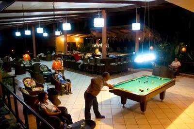 a man is playing pool in a bar at Turtle Beach Lodge in Tortuguero