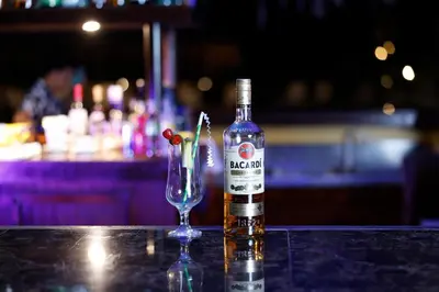 a bottle of alcohol sitting next to a wine glass at Turtle Beach Lodge in Tortuguero