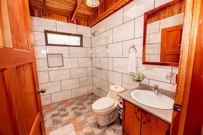 a bathroom with a toilet and a sink at Cabañas La Pradera in Monteverde Costa Rica