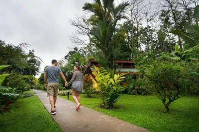 a man and woman walking down a sidewalk at Catarata Eco Lodge in Fortuna