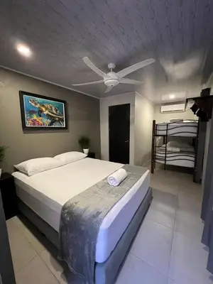 a bedroom with a bed and a ceiling fan at La Posada del Mar in Dominical