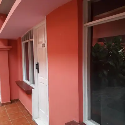 a house with an orange wall and a door at ECONOMiKA in Jacó