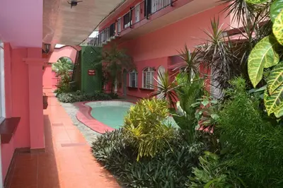 a building with a swimming pool in a courtyard at ECONOMiKA in Jacó