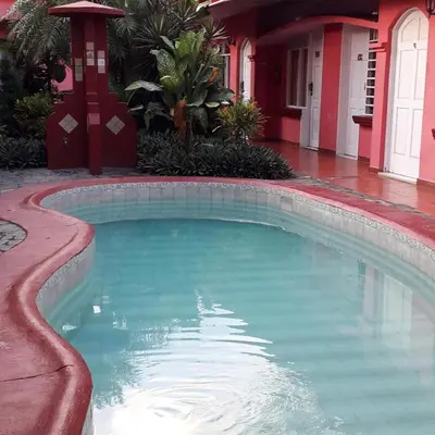 a swimming pool in front of a house at ECONOMiKA in Jacó