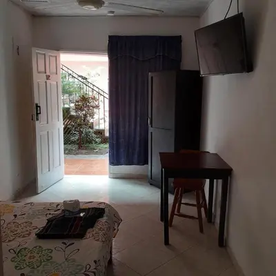 a room with a bed and a table and a desk at ECONOMiKA in Jacó